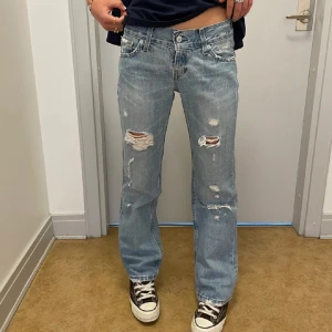 Ljusblå slitna jeans från Levis - Ljusblå Levis lågmidjadejeans