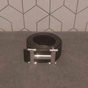 Svart Bälte med H-spänne - Säljer ett svart bälte med ett silver H-spänne. || 110 cm långt 