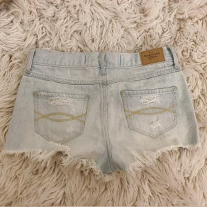 Ljusblåa jeanshorts  - SÄLJER MASSA FLERA SNYGGA LÅGMIDJADE SHORTS OCH TOPPAR💞Midja rakt över: ca 37 cm💞