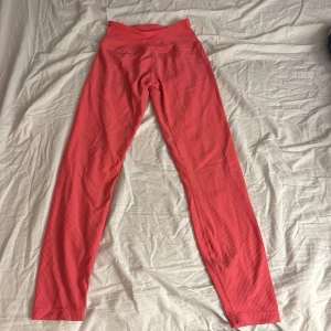 Rosa träningstights från SOC - Säljer ett par rosa ribbade träningstights från SOC i storlek S. De har hög midja och är tillverkade i ett stretchigt material som andas, perfekt för gym eller löpning.