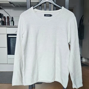Vit stickad tröja från Size & Needle - Säljer en enkel och stilren vit stickad tröja från Size & Needle. Inga fläckar. Tröjan har rund halsringning och långa ärmar, perfekt för lager-på-lager eller som den är. Passar till många olika stilar och tillfällen.