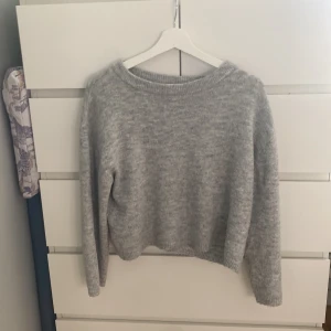 Ljusgrå stickad tröja från 157 - Mysig ljusgrå stickad tröja från 157. Tröjan har en rund halsringning och långa ärmar. Perfekt för lager-på-lager och enkel att matcha med olika outfits.