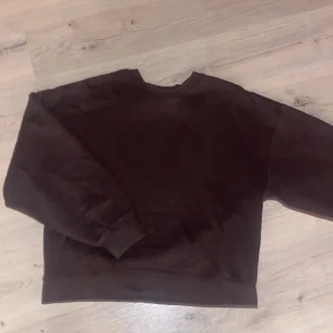 Brun sweatshirt från Gina Tricot - Säljer en brun sweatshirt från Gina Tricot, basically basics-kollektionen. Tröjan har en klassisk rund hals och långa ärmar. Perfekt för en avslappnad stil. Mjuk insida för extra komfort.