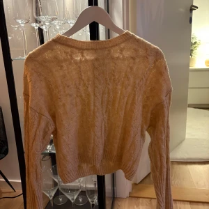 Beige stickad tröja - Säljer en beige stickad tröja med kabelstickat mönster.