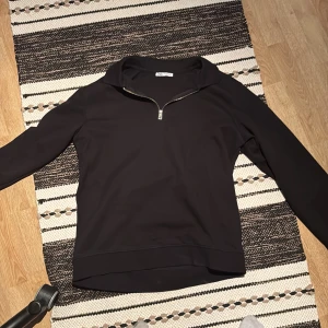 Svart half zip me krage från Zara - Säljer en stilren svart tröja från Zara med dragkedja vid halsen. Perfekt för en avslappnad look. Tröjan har långa ärmar och en bekväm passform. Nytt skick 