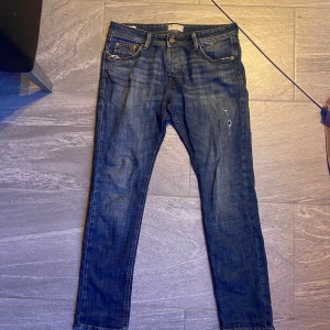 Jack an Jones jeans modell Slim Glenn - Snygga blå jeans från Jack and Jones med en slim passform. De har en liten slitning på benet för en trendig look. Storleken är 31 30. Dem är i väldigt bra skick och sparsamt använda. Om du har några frågor är det bara att höra av dig/ Max