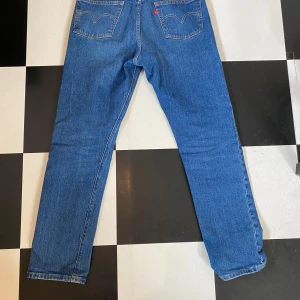 Blå Levis 501 jeans - Klassiska blå Levis 501 jeans med rak passform och knappgylf. Tillverkade i slitstarkt denim med den ikoniska Levis-lappen på baksidan. Hör av dig om du har några frågor! Mvh Felix