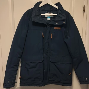 Blå jacka från Columbia - Säljer en snygg blå jacka från Columbia. Jackan har praktiska fickor med dragkedja. Perfekt för kyligare dagar med sin stilrena design och funktionella detaljer, jackan även ingen luva. Hör av er vid frågor och funderingar!