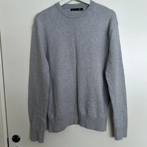 Grå tröja från 157 - Säljer en stilren grå tröja från 157 i storlek S. Tröjan har en klassisk rund hals och långa ärmar, perfekt för en enkel och avslappnad look. Den är tillverkad i ett mjukt material som känns skönt mot huden. Inga defekter.