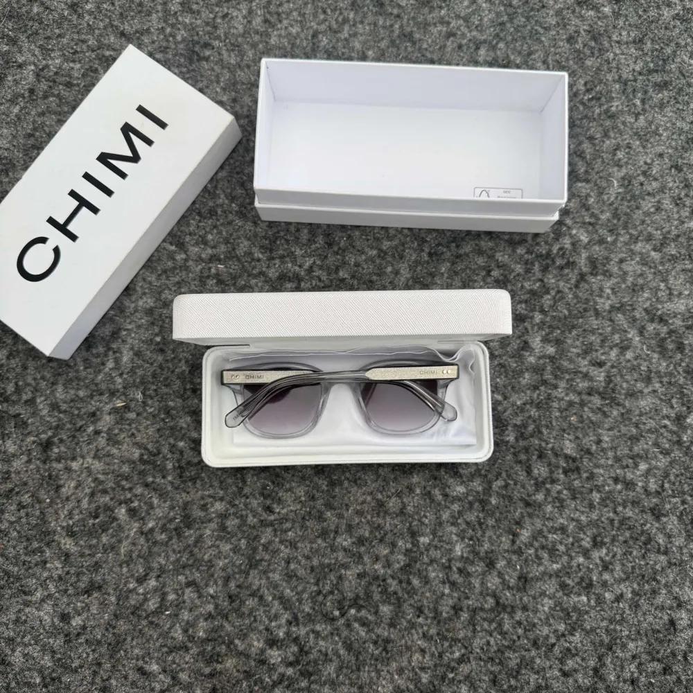 Snygga solglasögon från Chimi med transparent båge och mörka linser. Perfekta för en stilren look. Modellen 02 Grey. Kommer i originalförpackning. Passar perfekt nu till sommaren. Hör av dig vid frågor eller funderingar✅.. Asusteet.
