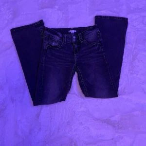 Svarta jeans från Gina Tricot - Snygga svarta jeans från Gina Tricot med klassisk femficksdesign och dubbla knappar i midjan. Perfekta för en stilren look. Passar bra till både vardag och mer uppklädda tillfällen.