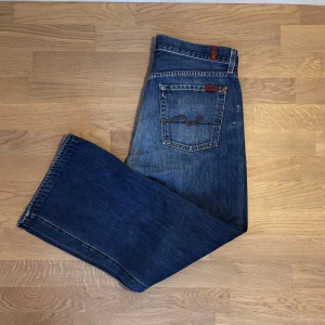 Blå jeansbyxor - Säljer ett par klassiska blå jeansbyxor. De har en rak passform med normal midja och traditionella femficksdetaljer. Perfekta för en avslappnad stil.