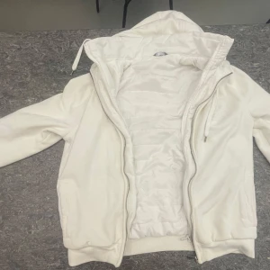 Hoddie jacka med tunn puffer innifrån - Säljer en stilren vit jacka från Max med huva och dragkedja. Quiltad på insidan för extra värme. Riktigt fet, bra skick. Köpt i Dubai, varan säljs inte längre
