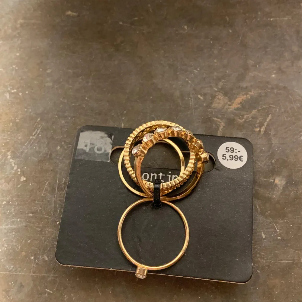Säljer ett set med guldiga ringar, varav en är dekorerad med glittrande stenar. Perfekt för att lägga till lite bling till din outfit. Passar bra att bära tillsammans eller var för sig.. Asusteet.