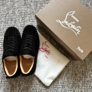 Christian Louboutin svarta sneakers med nitar - Stilrena svarta Louboutin-skor med nitar storlek 42 säljes. Dessa skor är i utmärkt skick och har endast använts ett fåtal gånger. Perfekt för dig som vill addera en touch av lyx till din outfit. Snabb leverans garanteras!