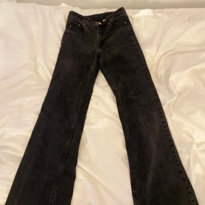 Svarta bootcut jeans från Bikbok - Snygga svarta bootcut jeans från Bikbok i storlek 34. Hög midja och klassisk femficksmodell. De är bootcut och medelhög i midjan skulle jag säga. Jeansen har en mörk tvätt och är tillverkade i denim. De är lite slitna längst ner på byxbenet men det syns inte. Perfekta för dig som gillar en tidlös och trendig look. Priset kan diskuteras!