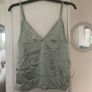 Satinlinne från Zara💕 - Supersnyggt ljusgrönt linne från Zara✨aldrig använt och prislapp är kvar!! Superfin att ha nu till sommaren🩷den behöver strykas lite innan användning men annars supersnygg!! Baksidan är stickad vilket är en cool detalj✨Bara att skriva om ni vill ha fler bilder!!