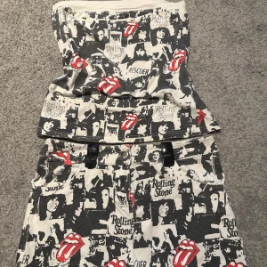 Rolling Stones set med tryck - Tubtop med kortkjol i svartvitt collage-tryck och röda Rolling Stones-tungor. Kjolen har fickor fram, bälteshällor och coola detaljer.