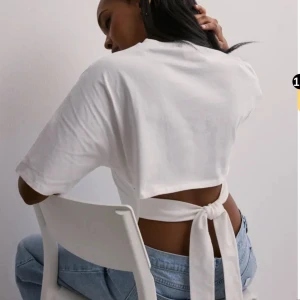 Vit croppad topp med knyt i ryggen - Säljer en vit croppad topp med korta ärmar och snygg öppen rygg som knyts baktill. Toppen är i mjuk bomull och passar grymt till jeans eller kjol. Finns en liten defekt vid halsen men inget som syns! Skriv för bild, pris går att diskutera💗