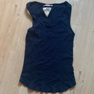 Mörkblå linnetopp  - En enkel och stilren mörkblå linnetopp  i storlek XS. Toppen är ärmlös med rund halsringning och tillverkad i mjuk bomull, perfekt för en avslappnad look eller till träning.