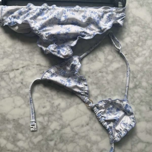Blåvit blommig bikini - Supersöt bikini i vitt med ljusblått blommönster 🩵endast använd max 2 gånger-vilket betyder att den är i som nytt skick! ❗️köp innan 25 juni då jag sedan tar bort artikeln om den inte blivit såld innan dess, eftersom jag ska resa❗️‼️