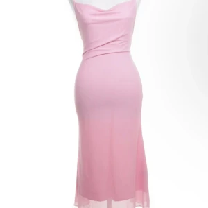 Ljusrosa långklänning med smala band - Supersöt ljusrosa långklänning med smala axelband som korsas i ryggen. Klänningen har en mjuk, figurnära passform och ett skirt ytterlager som ger en romantisk känsla. Perfekt för dig som vill sticka ut med en feminin och stilren look.