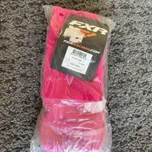 Fuchsia stickade vantar från FXR - Säljer ett par riktigt snygga stickade vantar från FXR i en intensiv fuchsia färg. De är ribbstickade vid mudden och perfekta för att hålla händerna varma under kalla dagar. Grymt statement-plagg för vintern!