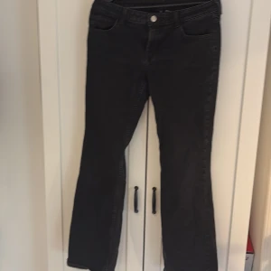 Svarta bootcut jeans från H&M - Svarta jeans från H&M i bootcut-modell med klassisk femficksdesign och knappgylf. Jeansen har en normal passform och är tillverkade i ett mjukt bomullsmaterial med lite stretch för extra komfort. Hör av dig vid inresse!💕