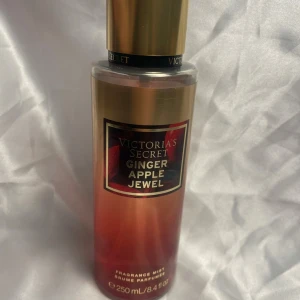 Victoria's Secret Ginger Apple Jewel Body Mist - En lyxig body mist från Victoria's Secret med doften Ginger Apple Jewel. Flaskan är guldig med röda detaljer och rymmer 250 ml. Perfekt för dig som gillar fruktiga och kryddiga dofter. Bara några sprut tagna 
