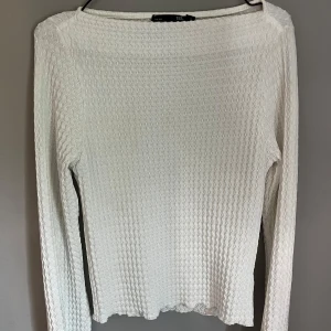 Vit ribbad långärmad topp - Säljer en vit långärmad topp med ribbad struktur. Tröjan har en rak passform och vida ärmar💕endast provad så i mycket bra skick.