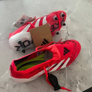 Adidas Predator fotbollsskor SG - Säljer ett par Adidas Predator SG fotbollsskor i rött med vita och svarta detaljer. 