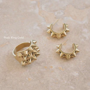 Guldiga Edblad peak örhängen  - Coola örhängen i guld med utstickande nitar runt hela ringen. Ger en edgy och trendig look, perfekta för dig som vill sticka ut. Passar både till vardags och när du vill addera lite extra attityd till din stil. Helt nya, Edblad ask ingår. Pris kan diskuteras, nypris 399kr