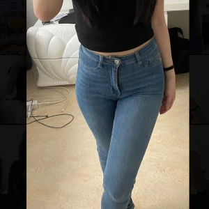 Ljusblå skinny jeans - Säljer ett par ljusblå skinny jeans med hög midja och klassisk femficksdesign. Jeansen har dragkedja och knapp framtill och är i stretchigt denimtyg som sitter tight längs benen. Perfekta till vardags med en crop top eller hoodie.