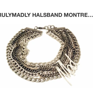 Chunky halsband med Mad-berlock från TrulyMadly - Säljer ett statement halsband från TrulyMadly med flera lager av grova kedjor i silverfärg. Halsbandet har en stor berlock med texten 'Mad' i metall. Perfekt för att lyfta din outfit!