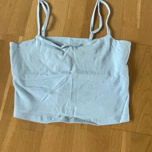 Ljusblå croppad linnetopp från 157 - Säljer en ljusblå croppad linnetopp från 157 med tunna axelband. Toppen är tillverkad i mjuk bomull med lite stretch för en skön passform. Perfekt till sommaren!