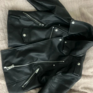 Svart skinnjacka med dragkedjor - Säljer en svart skinnjacka i klassisk bikerstil. Funkar som xs/s