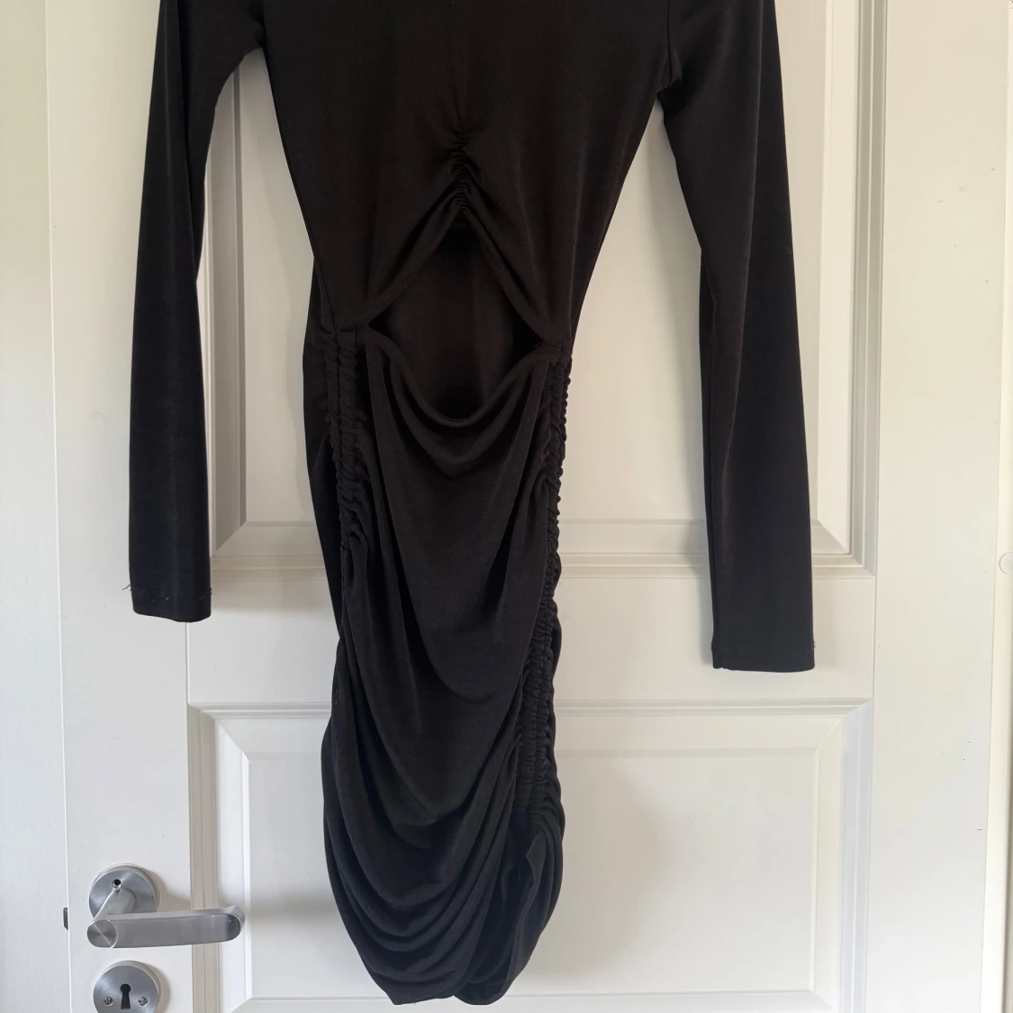 Svart långärmad klänning med rynkade detaljer - 1