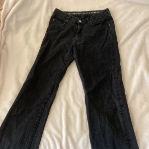 Svarta jeansbyxor från New Denim - Säljer ett par svarta jeansbyxor från New Denim med låg midja och straight fit. Byxorna har klassisk femficksdesign, knappgylf och diskreta nitar vid fickorna. Midjemått W30 och längd 32. Byxorna kommer även från Bik bok