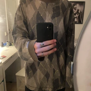 Brun och grå mönstrad tröja från Weekday - Säljer en oversized långärmad tröja från Weekday i storlek M. Tröjan har ett rutigt mönster i olika nyanser av brunt och grått med inslag av gult. Mjuk bomullskänsla och breda muddar vid ärmslut och halsringning.