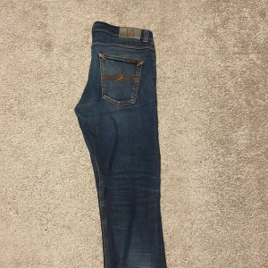 Nudie Jeans lean dean - Säljer ett par blåa nudie jeans. Passformen är slim på mig som är 183. Bredden upplevs mindre enligt mig, det står 33 men känns som 31. Säljs då de inte används.                                                                        Pris kan sänkas vid snabb affär