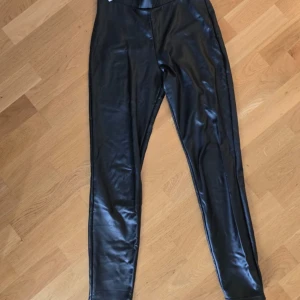 Svarta leggings i skinnimitation från FB Sister och en jätte fint topp  - Säljer sett : svarta leggings i skinnimitation från FB Sister. De har hög midja och en tight passform som ger en snygg siluett. Perfekta att styla med en oversized tröja eller crop top för en trendig look. Och kort sweatshirt med inskription💘✅