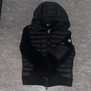 Svart moncler cardigan - Säljer en svart moncler cardigan som jag köpte helt ny för tre veckor sedan från moncler hemsida, använd ungifär 3-5 gånger och i riktigt bra skick, nfc taggen funkar jätte bra, varm som bara den!                                                                  Den är kort i storleken.                                           Pris går att diskutera!