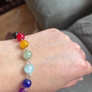 Färgglatt armband med pärlor - Säljer ett armband med silverfärgad kedja och sju runda pärlor i olika färger: svart, röd, orange, grön, ljusblå, blå och lila. Perfekt för dig som gillar färg och vill ha en unik accessoar. Armband liknar Sophie by Sophie chillihood  , hämta i Majorna 