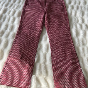 Mönstrade byxor från Max Mara Weekend - Säljer ett par snygga byxor från Max Mara Weekend i rött och vitt mönster. Byxorna har raka ben, normal passform och stängs med knapp och dragkedja. Tillverkade i bomull med lite stretch för extra komfort.