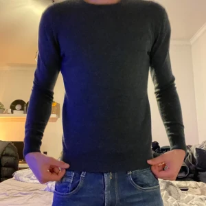 Mörkgrön merinoulltröja från H&M - Säljer en stilren mörkgrön långärmad tröja från H&M i mjuk merinoull. Tröjan har rund halsringning och en smal passform som sitter snyggt på kroppen. Perfekt för lager-på-lager eller som den är. Säljer pga av att den är för liten🤩