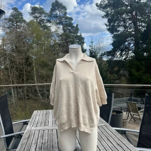 Beige stickad tröja med krage från & Other Stories - Säljer en oversized beige stickad tröja från & Other Stories i storlek L. Tröjan har en bred krage och v-ringning framtill, samt ribbade muddar vid ärmslut och nederkant. Perfekt för lager-på-lager och en avslappnad look. Den passar perfekt till sommarkvällar🥰