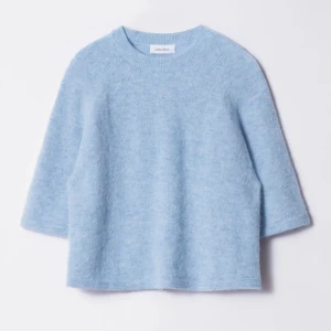 Ljusblå stickad tröja från & Other Stories - Supermjuk ljusblå stickad tröja från & Other Stories Stockholm Atelier. Tröjan har trekvartsärm och rund halsringning, perfekt för lager-på-lager. Enkel och stilren design som passar till mycket.