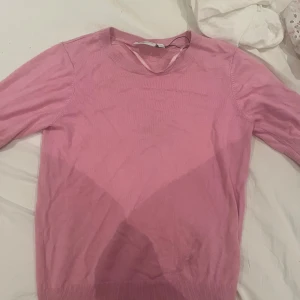 Rosa stickad tröja - Säljer en enkel och mjuk rosa stickad tröja med rund halsringning. Tröjan har långa ärmar och ribbade muddar vid ärmslut och nederkant. Perfekt för lager-på-lager och passar till många olika stilar.