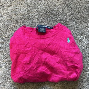 Rosa tröja från Ralph Lauren Sport - Säljer en rosa tröja från Ralph Lauren Sport i 100% merinoull. Tröjan har rund halsringning och den klassiska broderade loggan på bröstet. Perfekt för dig som vill ha en färgstark och stilren look.