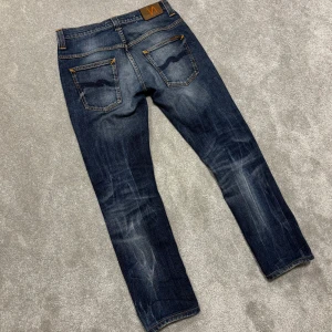 Nudie Jeans - Tja! Säljer dessa sjukt snygga mörkblå/grå/blå Nudie jeans med extremt najs tvätt!  Size 30/32. De ska egentligen vara slim, men sitter tajatare pga tvättning. Ena fickan har hål. Skriv vid funderingar!